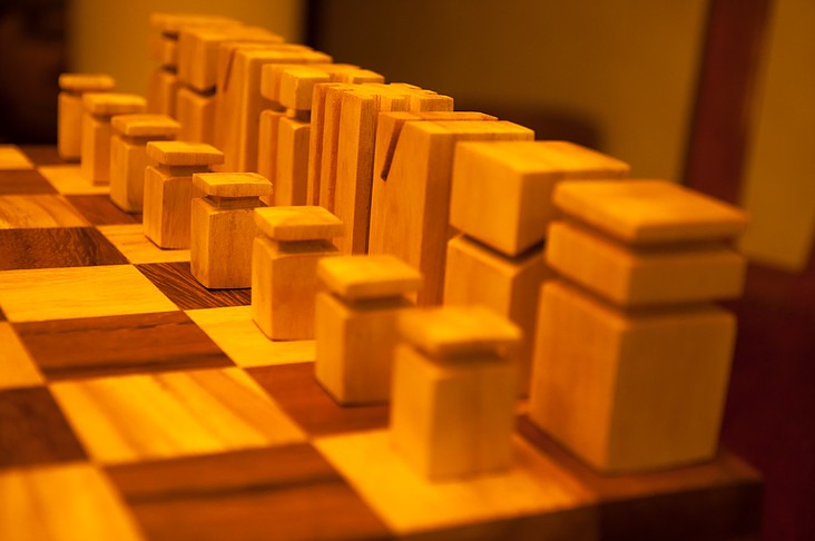 Close-up of the geometric chess pieces showing the grain and cut of each wood