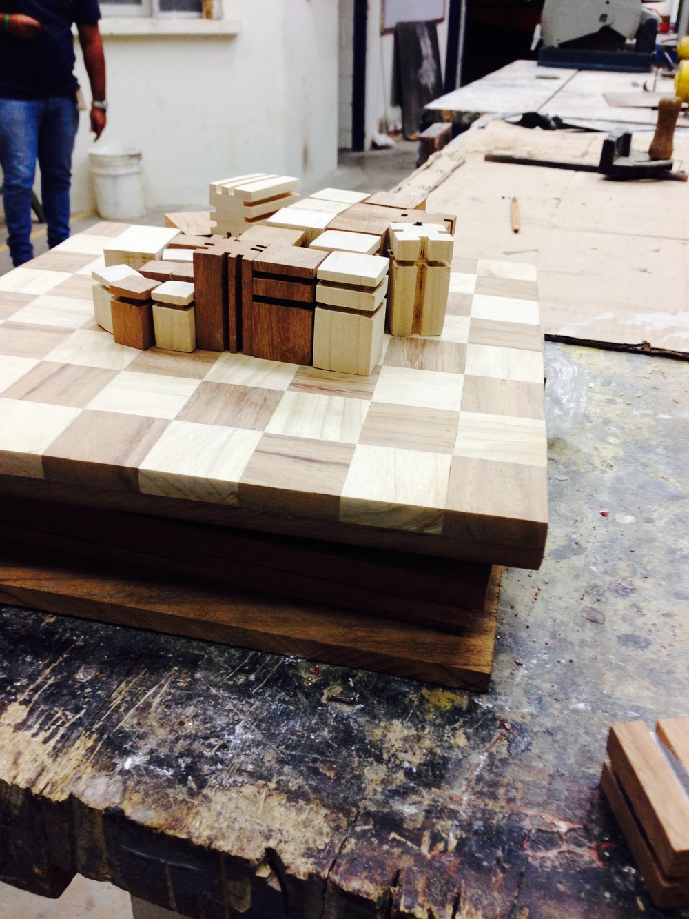Rough-cut chess pieces arranged on the unfinished checker board, before final shaping