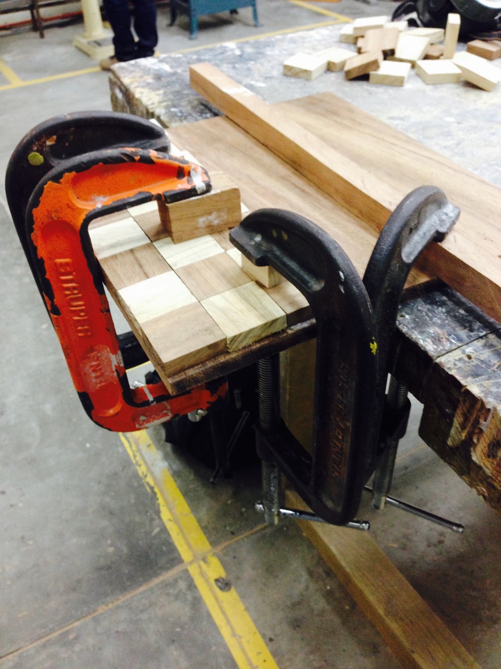 A small section of the checker pattern clamped while the glue sets
