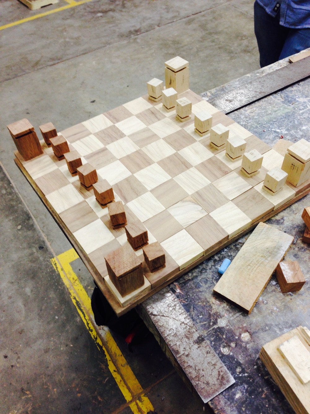 The glued-up board on the workshop floor with pieces sorted in a line from dark to light