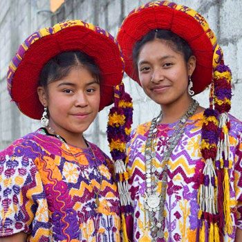 Two women wearing traditional huipiles